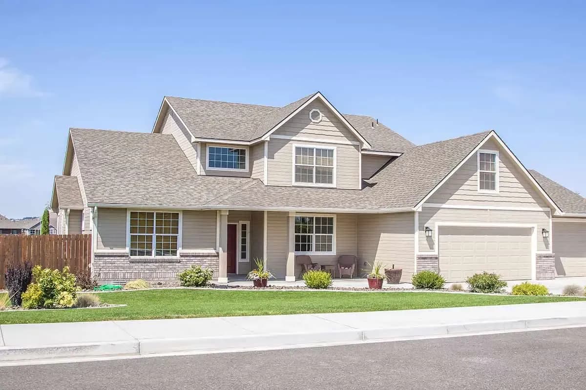 Tan house with bright green yard - homepage hero image